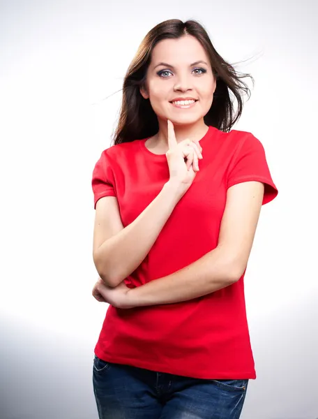 Attraktive lächelnde junge Frau im roten Hemd, die ihren Finger hält — Stockfoto