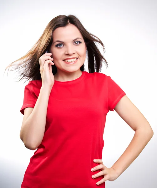 Kırmızı gömlekli bir mobil konuşma çekici gülümseyen genç kadın — Stok fotoğraf