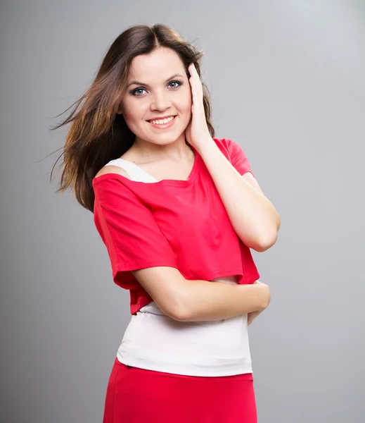 Aantrekkelijke jonge vrouw in een rode shirt en de rok. — Stockfoto