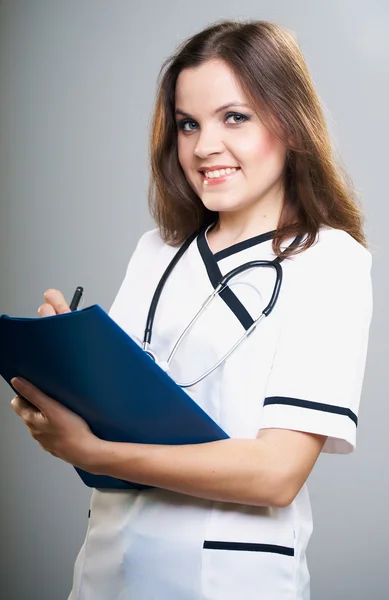 Attraktiv ung sjuksköterska. innehar en blå mapp. — Stockfoto