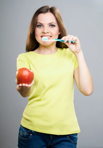 Aantrekkelijke jonge vrouw in een gele overhemd. houden van een tandenborstel w — Stockfoto