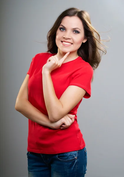 Una joven atractiva con una camisa roja. Sosteniendo su dedo sobre ella —  Fotos de Stock