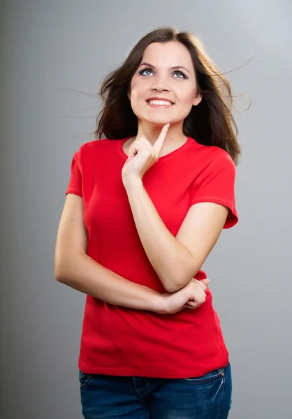 Attractive young woman in a red shirt. Holding her finger on her — Stock Photo, Image