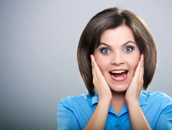 Surprised young woman in a blue shirt. Isolated on a gray backgr — Stock Photo, Image