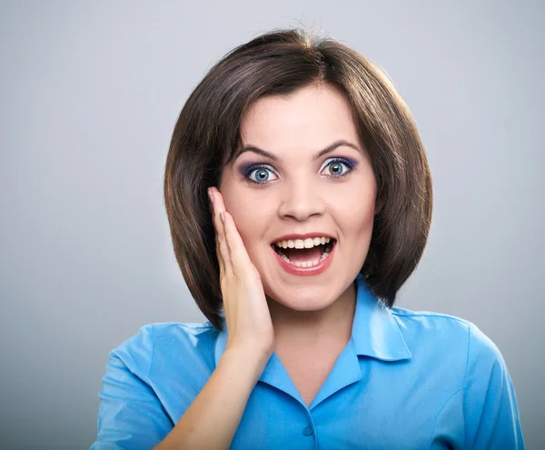 Una giovane donna sorpresa con una camicia blu. Isolato su un dorso grigio — Foto Stock