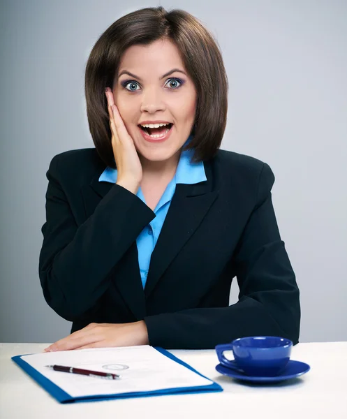 Überraschte junge Frau in schwarzer Jacke und Brille am Tisch sitzend — Stockfoto