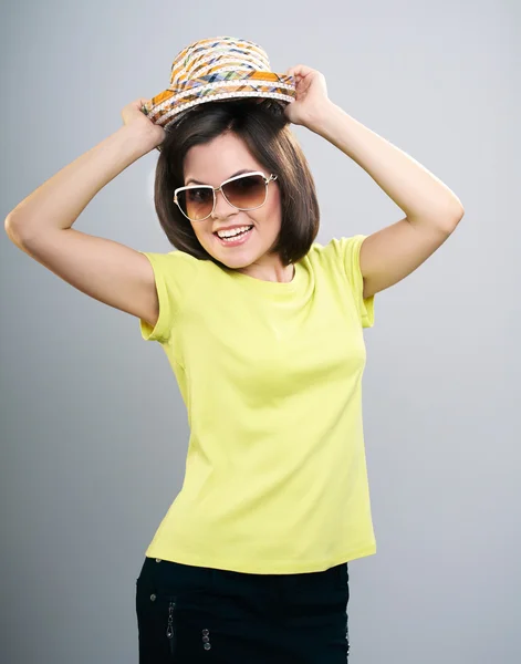 Glückliche junge Frau in gelbem Hemd und Sonnenbrille. hat einen Hut. — Stockfoto