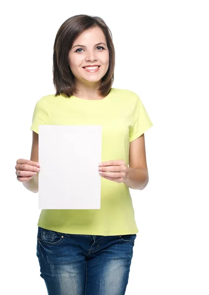 Aantrekkelijke jonge vrouw in een gele shirt en spijkerbroek. houdt een — Stockfoto