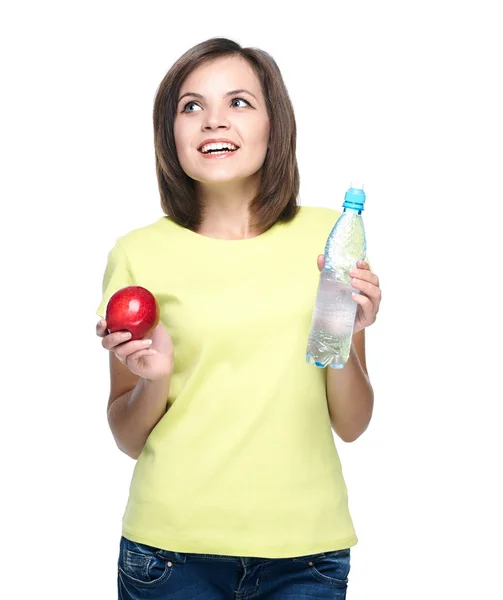 Attractive young woman in a yellow shirt. Holds a red apple and — Stock Photo, Image