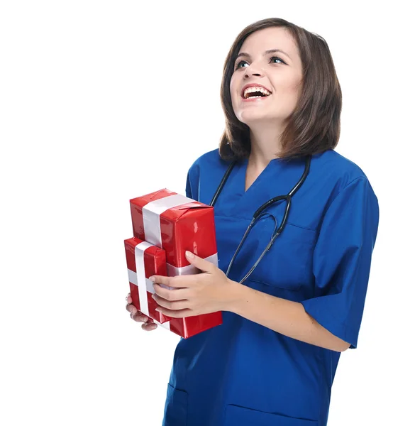Jovem enfermeira feliz com um estetoscópio. Mantém uma caixa de presente . — Fotografia de Stock