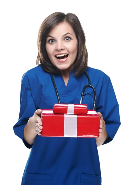 Surprise jeune infirmière tenant une boîte-cadeau. Isolé sur le dos blanc — Photo