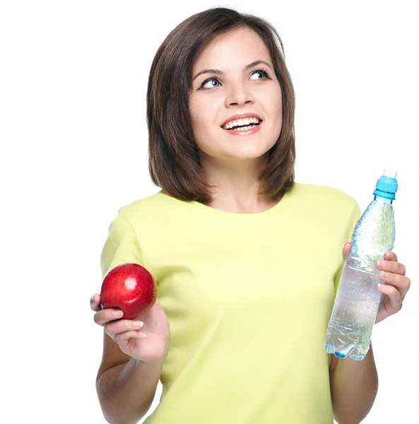 Attractive young woman in a yellow shirt. Holds a red apple and — Stock Photo, Image