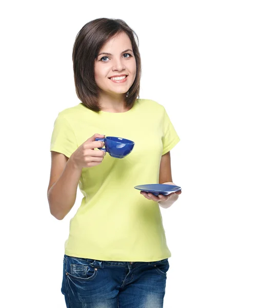 Attractive young woman in a yellow shirt. Holds a blue cup. — Stock Photo, Image