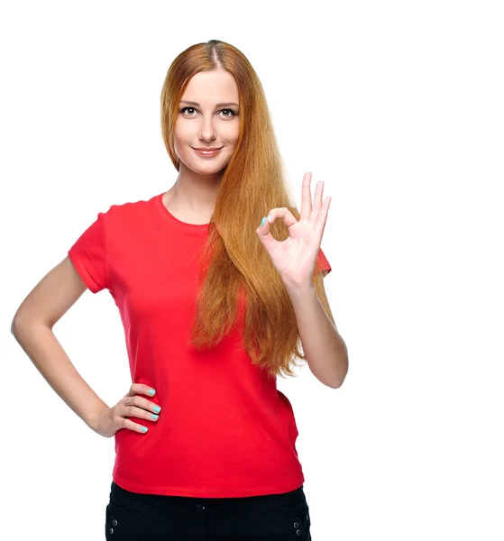 Una joven atractiva con una camisa roja. Muestra signo bien . — Foto de Stock