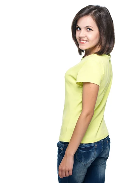 Attractive young woman in a yellow shirt and blue jeans. Isolate — Stock Photo, Image