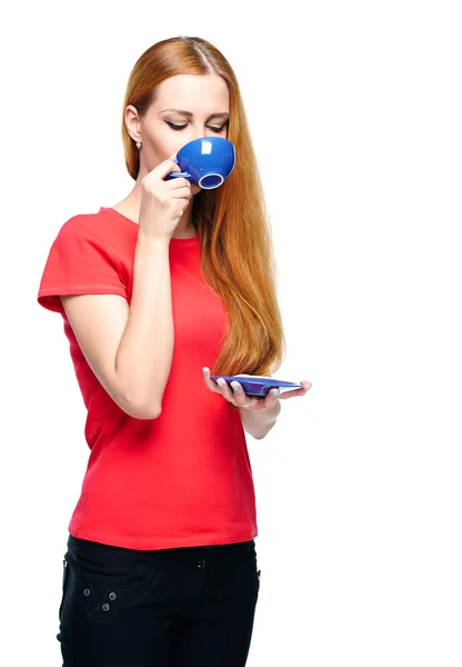 赤シャツの魅力的な若い女性。ブルーのカップから飲む. — ストック写真