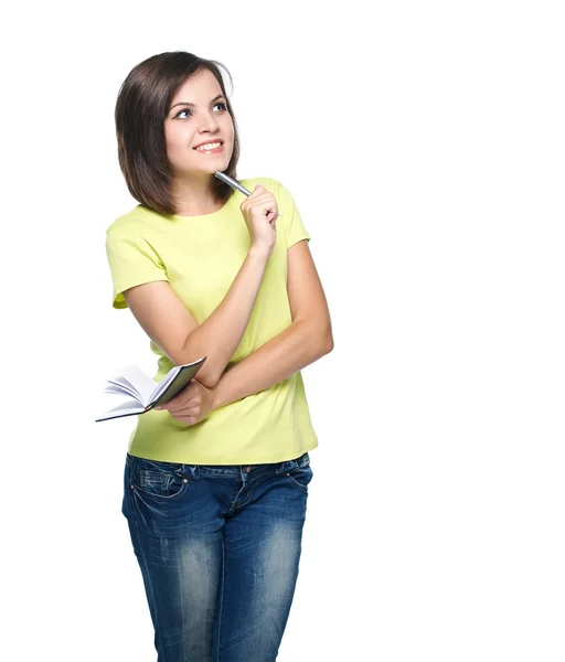 Una joven atractiva con una camisa amarilla. Mantenga un bloc de notas y una pluma —  Fotos de Stock