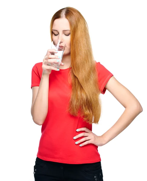 Aantrekkelijke jonge vrouw in een rode shirt. drinken van mineraalwater. — Stockfoto