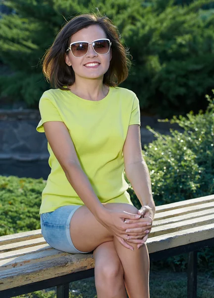 Привлекательная молодая женщина в желтой рубашке и солнечных очках. Женщина и — стоковое фото