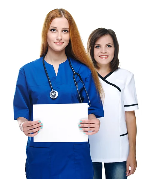 Dos atractivas enfermeras de uniforme. Una enfermera sosteniendo un cartel. Aislamiento —  Fotos de Stock