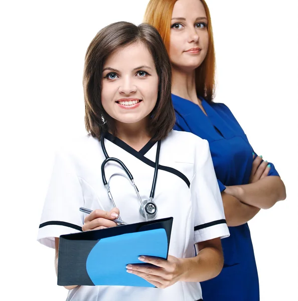 Dos atractivas enfermeras de uniforme. Una enfermera sosteniendo la carpeta y p — Foto de Stock