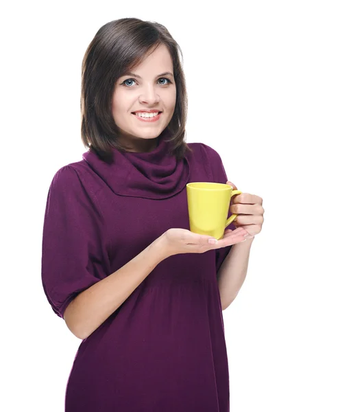 Atractiva joven con un vestido rojo. Sostiene una taza amarilla . — Foto de Stock