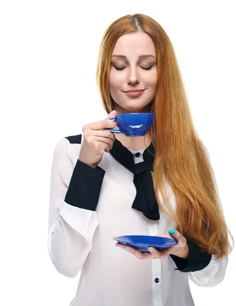 Una joven atractiva con una blusa blanca. Sostiene una taza azul y s — Foto de Stock