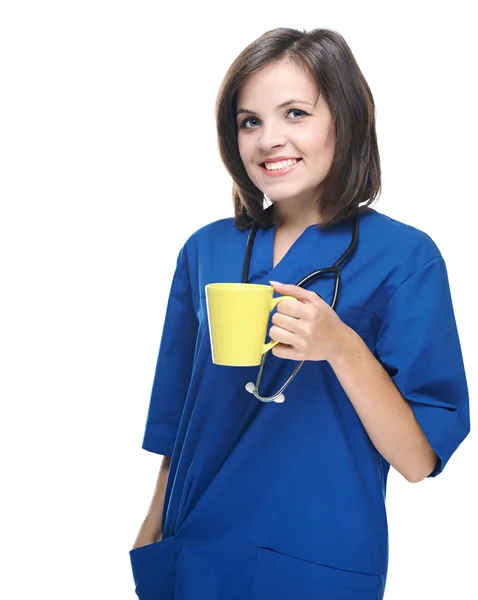 Attractive young nurse in uniform. Holds a yellow cup. Isolated — Stock Photo, Image