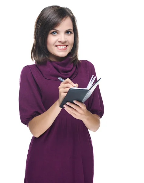 Attractive young woman in a red dress. Holds a notebook and some — Stock Photo, Image