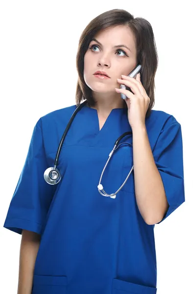 Una joven enfermera atractiva con un estetoscopio. Hablando en un móvil p —  Fotos de Stock