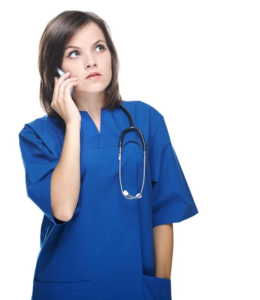 Una joven enfermera atractiva con un estetoscopio. Hablando en un móvil p —  Fotos de Stock