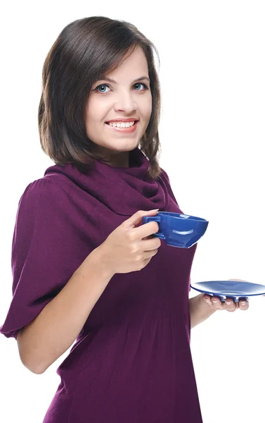 Attraktive junge Frau im roten Kleid. hält eine blaue Tasse und Untertasse — Stockfoto