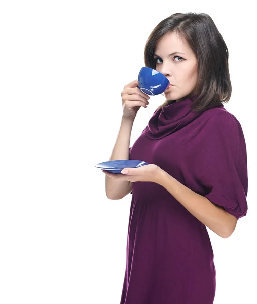 Atractiva joven con un vestido rojo. Beber de una taza azul . — Foto de Stock