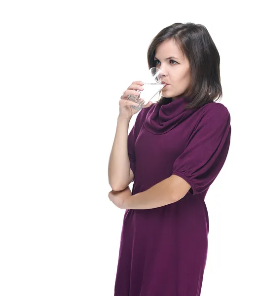 Atraktivní mladá žena v červených šatech. pití minerální vody. — Stock fotografie