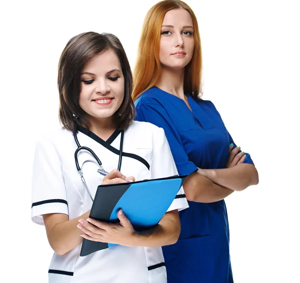 Two attractive nurses in uniform. One nurse holding folder and p — Stock Photo, Image