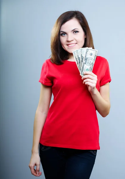 Aantrekkelijke jonge vrouw in een rode shirt. aanhouden van geld. — Stockfoto