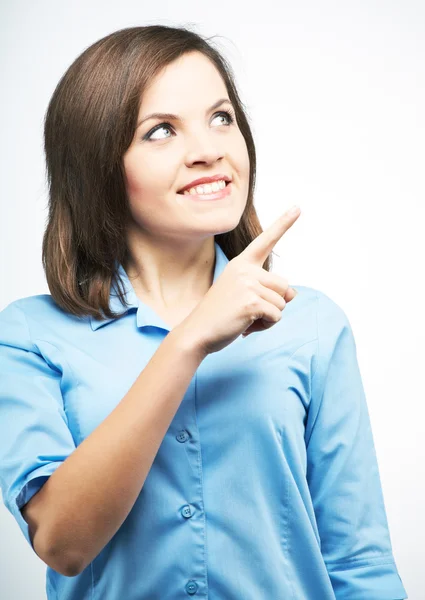 Uśmiechnięta młoda kobieta w niebieskie bluzki. wskazuje palcem w th — Zdjęcie stockowe