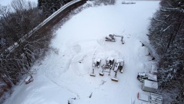 Aerial view with a drone of a road and excavator in winter  clipart