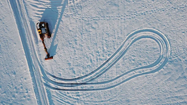 冬季在雪地里用挖掘机的无人机进行空中射击 — 图库照片