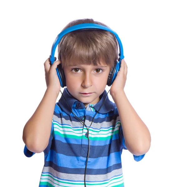 De jongen luistert naar muziek op de hoofdtelefoon. isoleren op wit. — Stockfoto