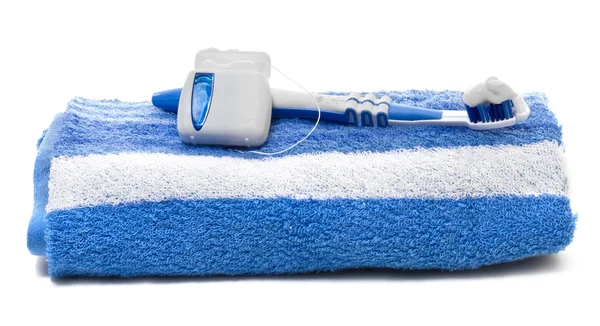 Dental floss and toothbrush, towel on a white background — Stock Photo, Image