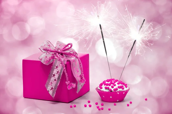 Birthday cake with sparkler and gift on a pink background — Stock Photo, Image