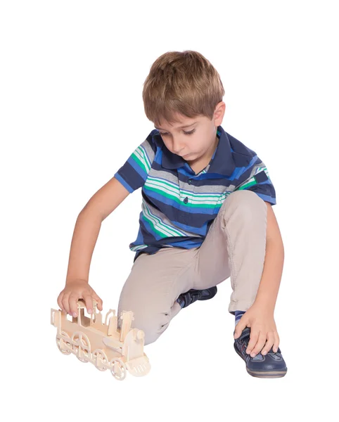 Chłopiec bawi się kolejką zabawka. na białym tle nad białym. — Zdjęcie stockowe