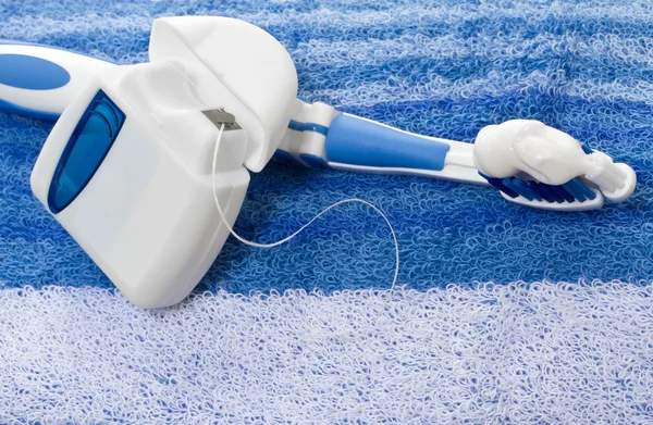 Dental floss and toothbrush on a towel — Stock Photo, Image