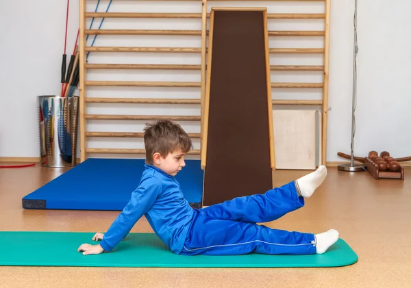 El niño es ejercicios terapéuticos en el gimnasio —  Fotos de Stock