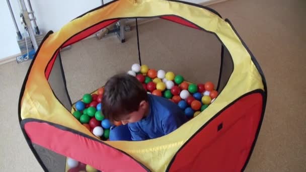 Kind spelen met gekleurde ballen — Stockvideo