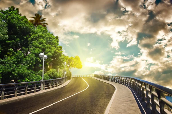 Autobahn mit bewölktem Himmel und Sonnenlicht — Stockfoto