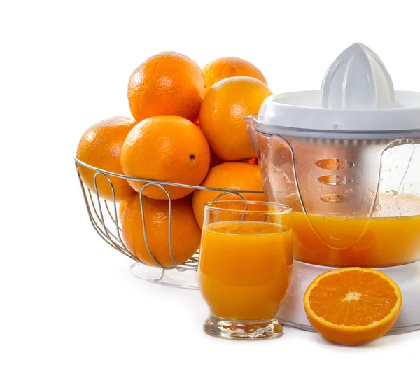 Juice extractor with juice and ripe oranges — Stock Photo, Image