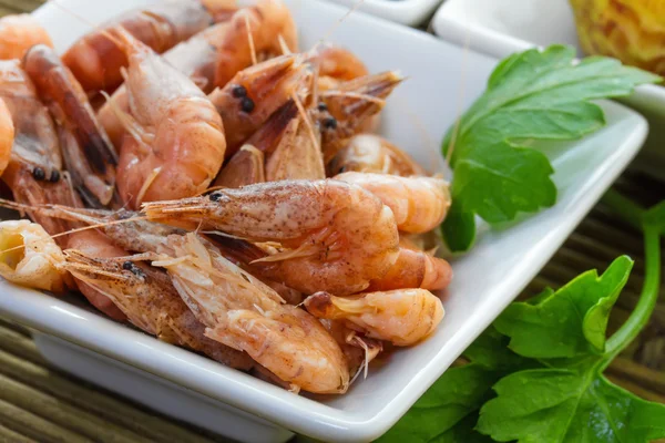 Crevettes de mer avec du persil sur la plaque — Photo