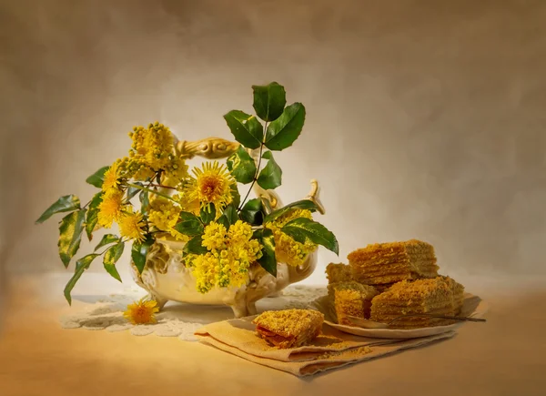 Νεκρή φύση με τα κίτρινα λουλούδια και ένα κέικ — Φωτογραφία Αρχείου